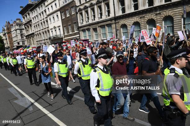 Protesters with anti-Conservative Party and anti-Democratic Unionist Party placards march along Whitehall in central London on June 10, 2017....