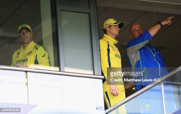 Steve Smith, Captain of Australia talks to Darren Lehmann, Coach of Australia, as David Warner looks on during a rain break during the ICC Champions...