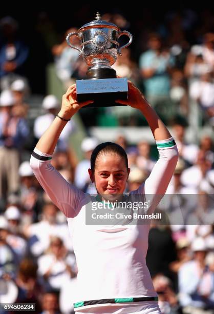 Jelena Ostapenko of Latvia celebrates victory with the trophy following the ladies singles final match against Simona Halep of Romania on day...