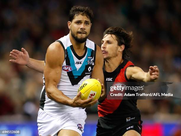 Paddy Ryder of the Power is tackled by Mark Baguley of the Bombers during the 2017 AFL round 12 match between the Essendon Bombers and the Port...