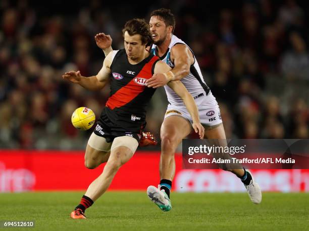 Andrew McGrath of the Bombers is tackled by Travis Boak of the Power during the 2017 AFL round 12 match between the Essendon Bombers and the Port...