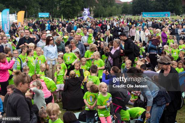 Crown Princess Mary of Denmark surrounded by kids during the warm-up exercise at the 'Children's Relay Run' in Faelledparken on June 10, 2017 in...