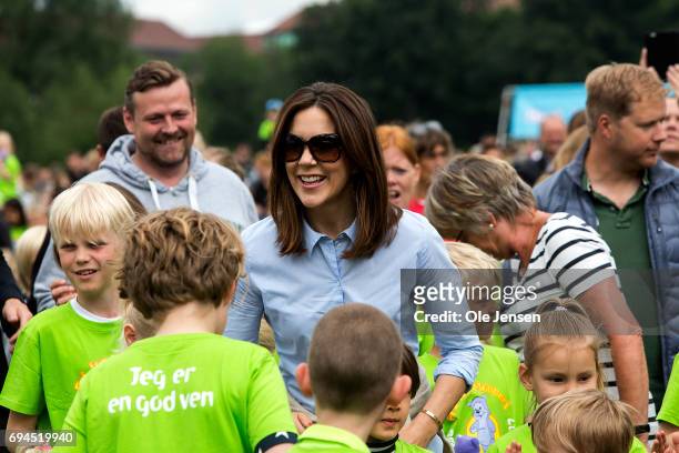 Crown Princess Mary of Denmark participates in the warm-up exercise during the 'Children's Relay Run' in Faelledparken on June 10, 2017 in...