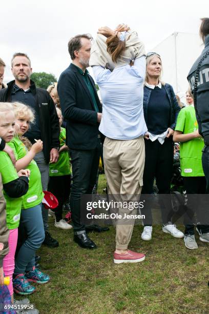 Crown Princess Mary of Denmark takes of her sweater during the 'Children's Relay Run' in Faelledparken on June 10, 2017 in Copenhagen, Denmark. The...