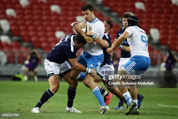 Alex Dunbar of Scotland tackles Leonardo Sarto of Italy during the International Test match between Italy and Scotland at Singapore Sports Stadium on...