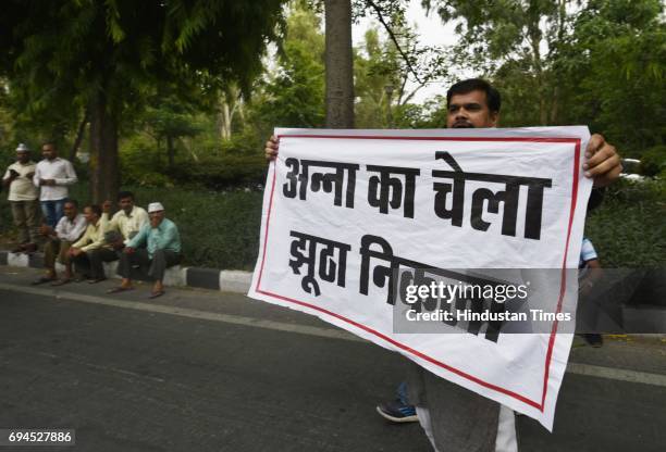 Supporters of sacked Aam Aadmi Party minister Kapil Mishra shout slogans and show banner during the AAP leaders'protest against Shivraj Singh's...