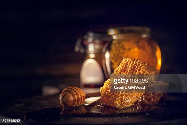 honing met honeycombs in een pot - honingraat stockfoto's en -beelden