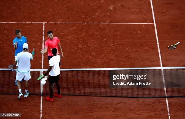 Ryan Harrison of The United States and partner Michael Venus of New Zealand shake hands with their opponants, following victory in the mens doubles...