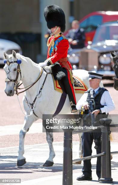 An armed police officer stands alongside Prince William, Duke of Cambridge as he takes part in The Colonel's Review on June 10, 2017 in London,...