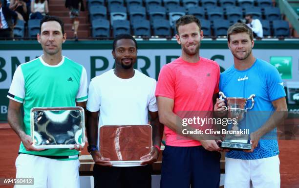 Ryan Harrison of The United States and partner Michael Venus of New Zealand hold their winners trophy as, Donald Young of The United States and...