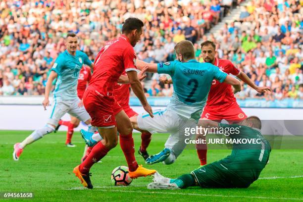 Slovenia's Nejc Skubic is tackled by Malta's Clayton Failla and Andrew Hogg during the Fifa World Cup 2018 football qualification match between...