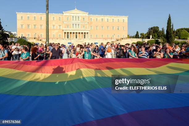 People hold a giant rainbow flag in front of the Greek parliament during the city's 6th Gay Pride march in Athens, on June 10, 2017.