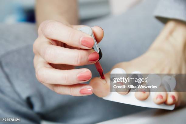 close up of a foot of an adult woman doing pedicure at home - pedicure stockfoto's en -beelden