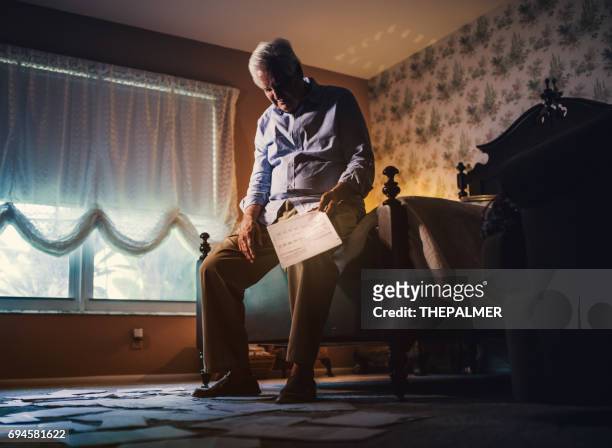 senior man overhandigen bank schuld documenten - arm around stockfoto's en -beelden