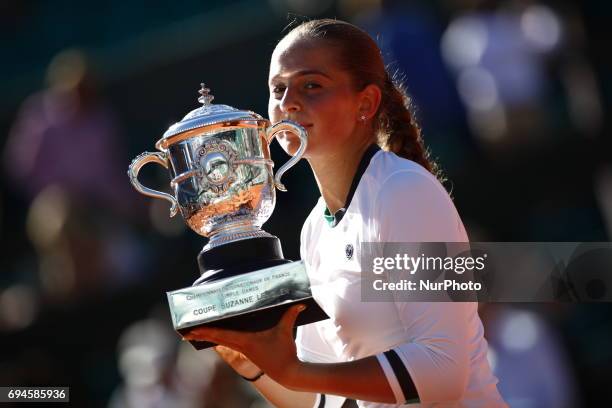 Jelena Ostapenko of Latvia lifts the Suzanne Lenglen Cup following her victory during the ladies singles final against Simona Halep of Romania on day...