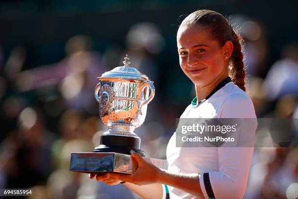 Jelena Ostapenko of Latvia lifts the Suzanne Lenglen Cup following her victory during the ladies singles final against Simona Halep of Romania on day...