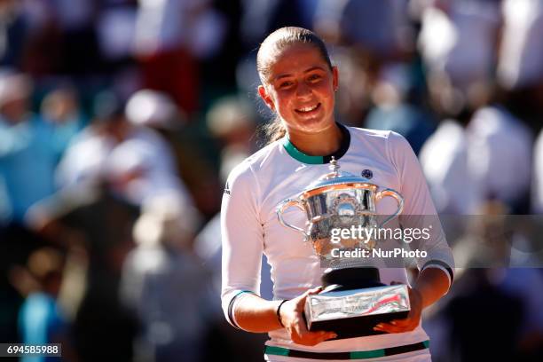 Jelena Ostapenko of Latvia lifts the Suzanne Lenglen Cup following her victory during the ladies singles final against Simona Halep of Romania on day...