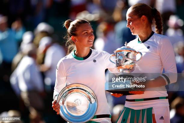 Winner, Jelena Ostapenko of Latvia and Runner up, Simona Halep of Romania hold their trophies following the ladies singles final match on day...