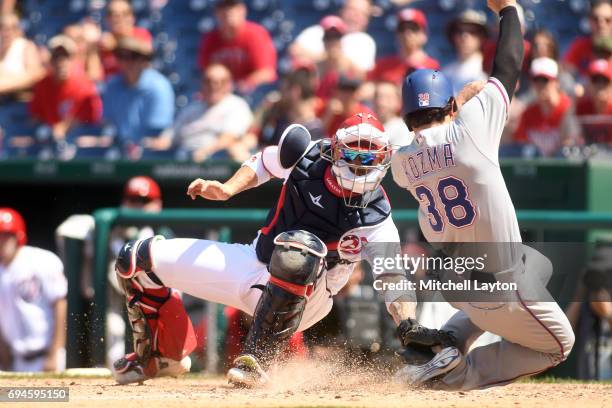 Jose Lobaton of the Washington Nationals tags out Pete Kozma of the Texas Rangers at the plat ein the ninth inning during a baseball game at...