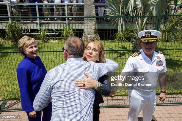 With former Secretary of State Hillary Clinton on one side and her husband, Captain Mark Kelly , on the other side, Gabrielle Giffords greets a well...