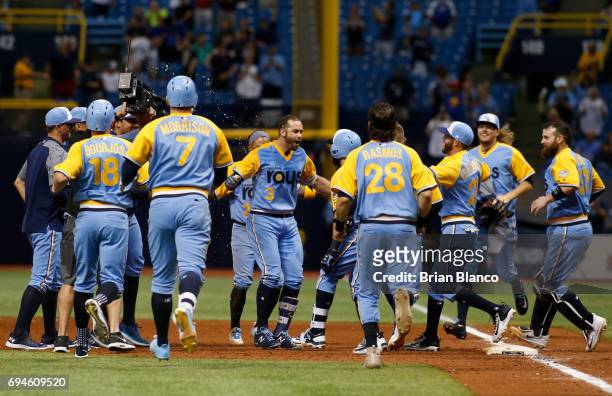 Evan Longoria of the Tampa Bay Rays, center, is surrounded by teammates after hitting a walk off RBI single to score Peter Bourjos during the 10th...
