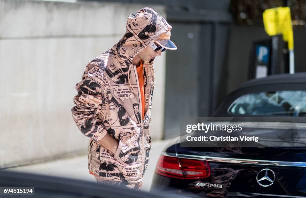 Alessandro Altomare wearing a hooded suit with print and cap during the London Fashion Week Men's June 2017 collections on June 10, 2017 in London,...