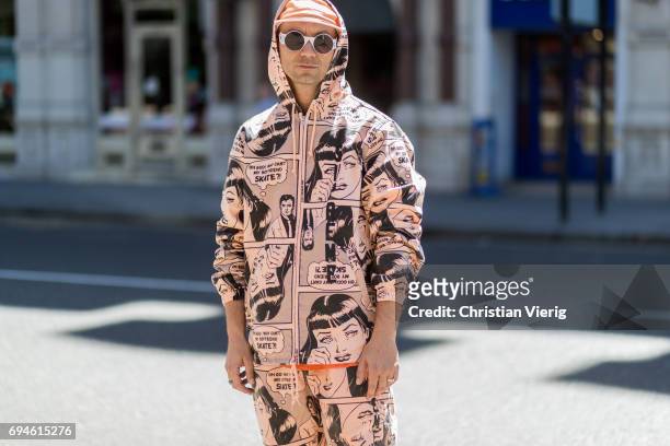 Alessandro Altomare wearing a hooded suit with print and cap during the London Fashion Week Men's June 2017 collections on June 10, 2017 in London,...