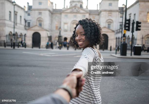 woman leading the way while traveling in london - following leader stock pictures, royalty-free photos & images