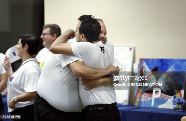 Members of The Orlando Gay Chorus share a hug at the conclusion of a memorial service on the first anniversary of the Pulse nightclub shootings, at...