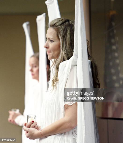 Amanda Garofalo, a volunteer with the 'Angels Force' group, pauses in reflection during the benediction at a memorial service on the first...