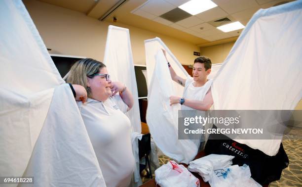 Jen Vargas and Tom Williams, volunteers with the 'Angels Force' group, get suited in their 'wings' for a memorial service on the first anniversary of...