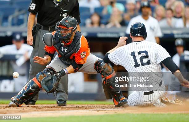 Welington Castillo of the Baltimore Orioles waits for the throw as Chase Headley of the New York Yankees slides home with a run in the first inning...