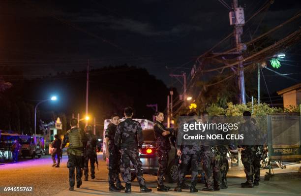 In this photo taken on June 10 police officers are seen outside a hospital in Iligan after they brought in the body of one of four suspected Maute...