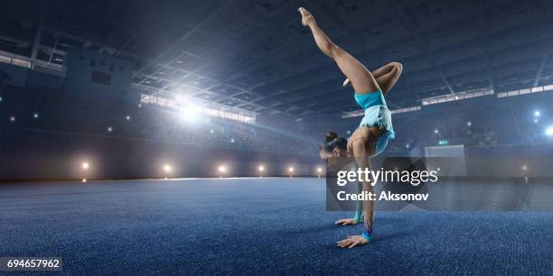a gymnast girl makes performance on a large professional stage - gymnast stock pictures, royalty-free photos & images