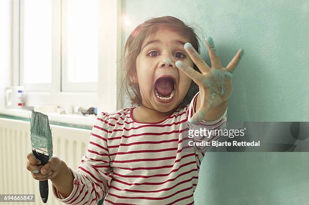 girl playing around while painting her bedroom - kids mess stockfoto's en -beelden