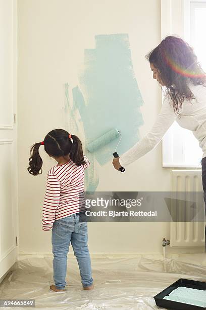 mother and daughter painting walls - bjarte rettedal stock pictures, royalty-free photos & images