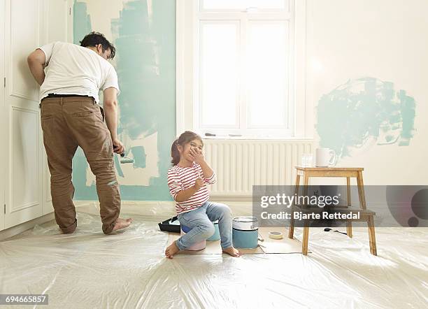 girl giggling while dad paints - bjarte rettedal stock pictures, royalty-free photos & images