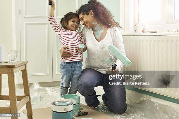 mother and daughter posing with paint tools - family hugging bright stock pictures, royalty-free photos & images