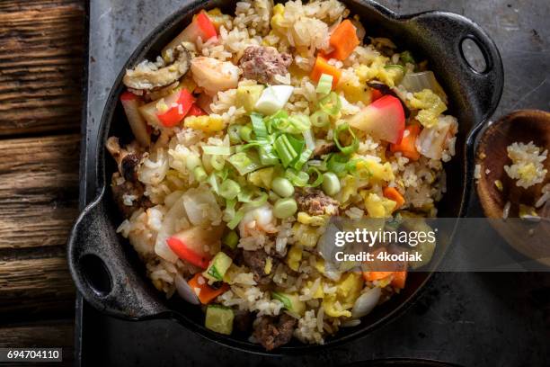 fried rice with shrimp and vegetables in cast iron pan with soy sauce - fried rice stock pictures, royalty-free photos & images