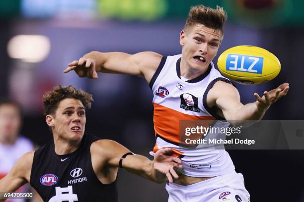 Adam Tomlinson of the Giants marks the ball against Charlie Curnow of the Blues during the round 12 AFL match between the Carlton Blues and the...