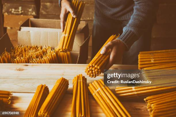 packing church candles. - beeswax stock pictures, royalty-free photos & images