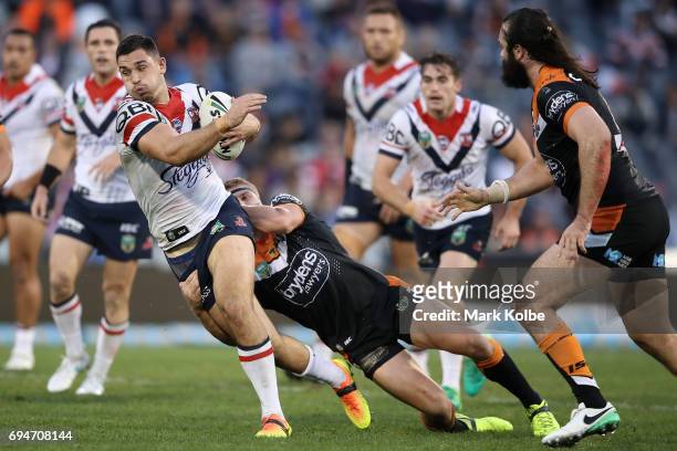 Ryan Matterson of the Roosters is tackled during the round 14 NRL match between between the Wests Tigers and the Sydney Roosters at Campbelltown...