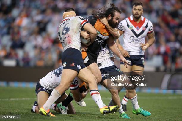 Aaron Woods of the Tigers is tackled during the round 14 NRL match between between the Wests Tigers and the Sydney Roosters at Campbelltown Sports...