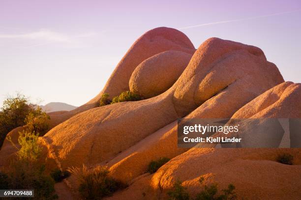 sunset sets on smooth sweeping boulders at joshua tree - sweeping landscape stock pictures, royalty-free photos & images