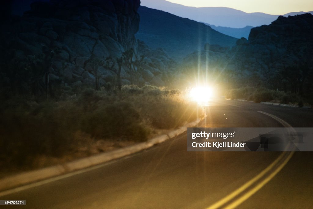Oncoming headlights from a car on desert road