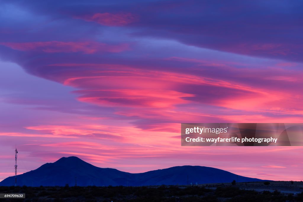 Lenticular cloud over sky at sunrise in pink and purple shade