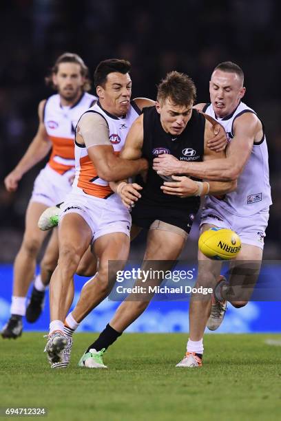 Patrick Cripps of the Blues is tackled by Dylan Shiel and Tom Scully during the round 12 AFL match between the Carlton Blues and the Greater Western...