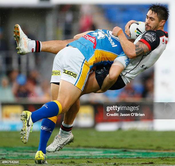 Shaun Johnson of the Warriors is tackled during the round 14 NRL match between the Gold Coast Titans and the New Zealand Warriors at Cbus Super...