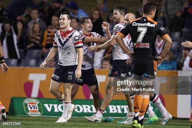 Connor Watson of the Roosters celebrates with his team mates after scoring a try during the round 14 NRL match between between the Wests Tigers and...