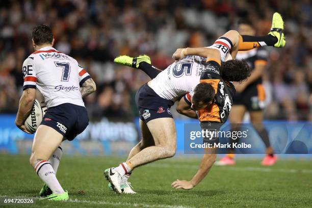 Aidan Guerra of the Roosters picks up and tackles Jack Littlejohn of the Tigers during the round 14 NRL match between between the Wests Tigers and...